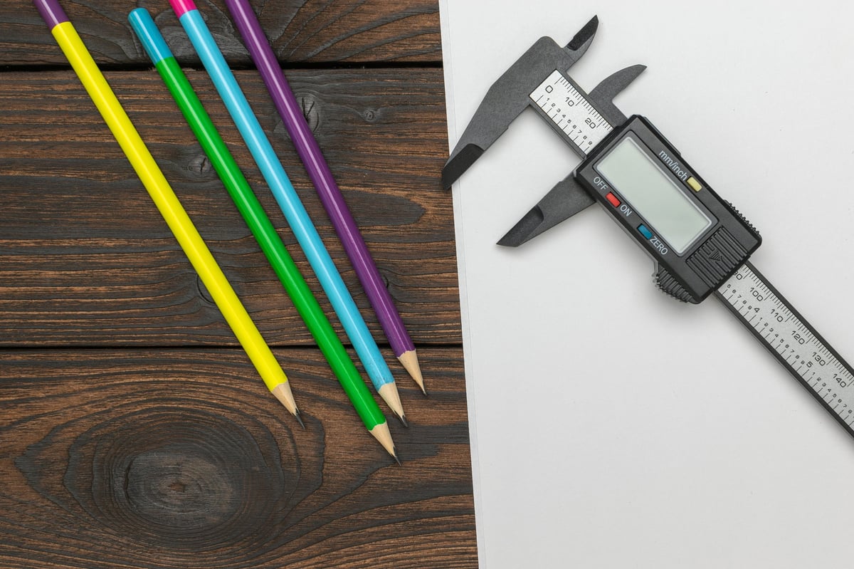 Calliper measurement of a reinforcing bar sample beside inspection paperwork, illustrating dimensional verification of a delivered lot.