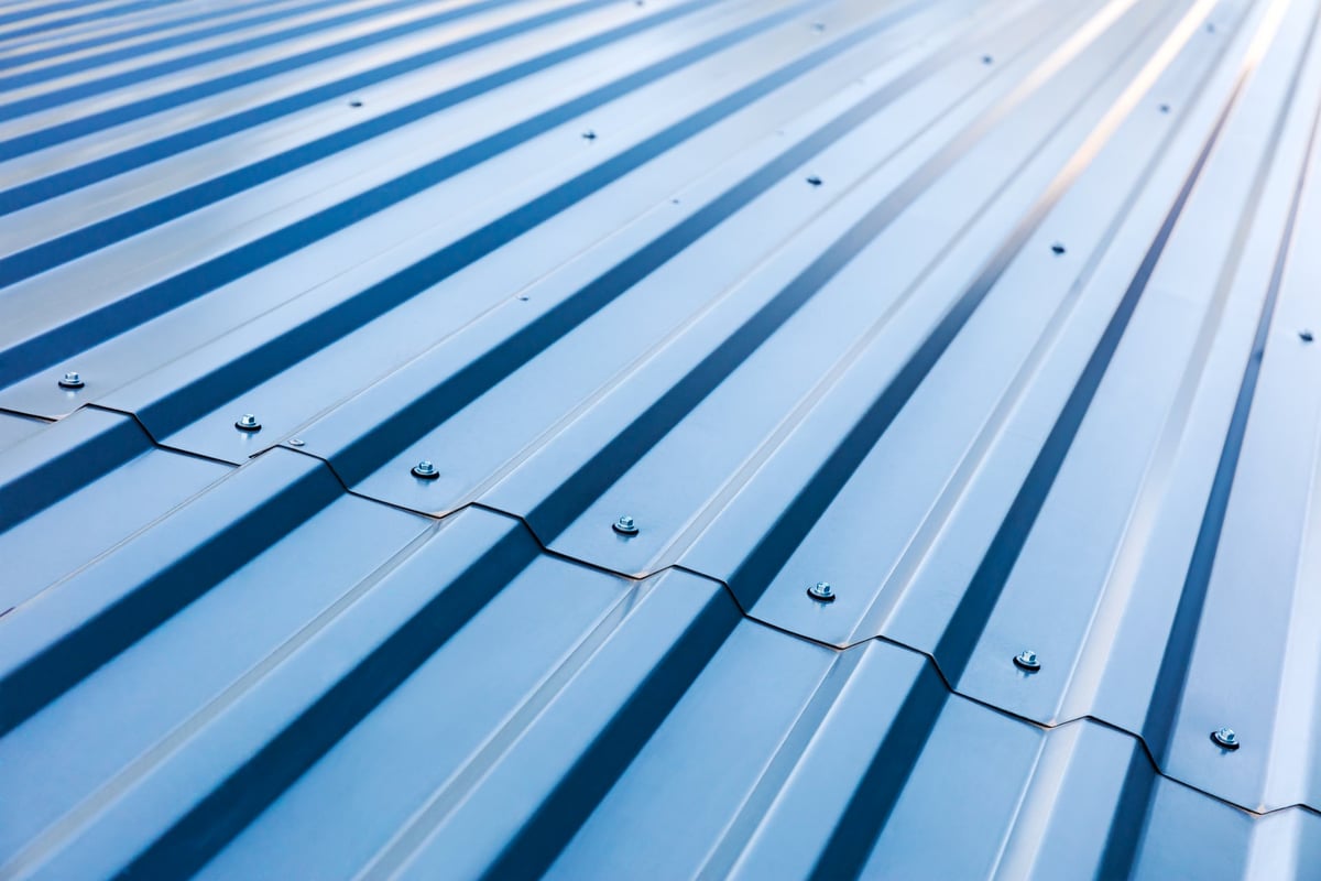 Coated corrugated steel cladding panels fixed in place on an industrial roof