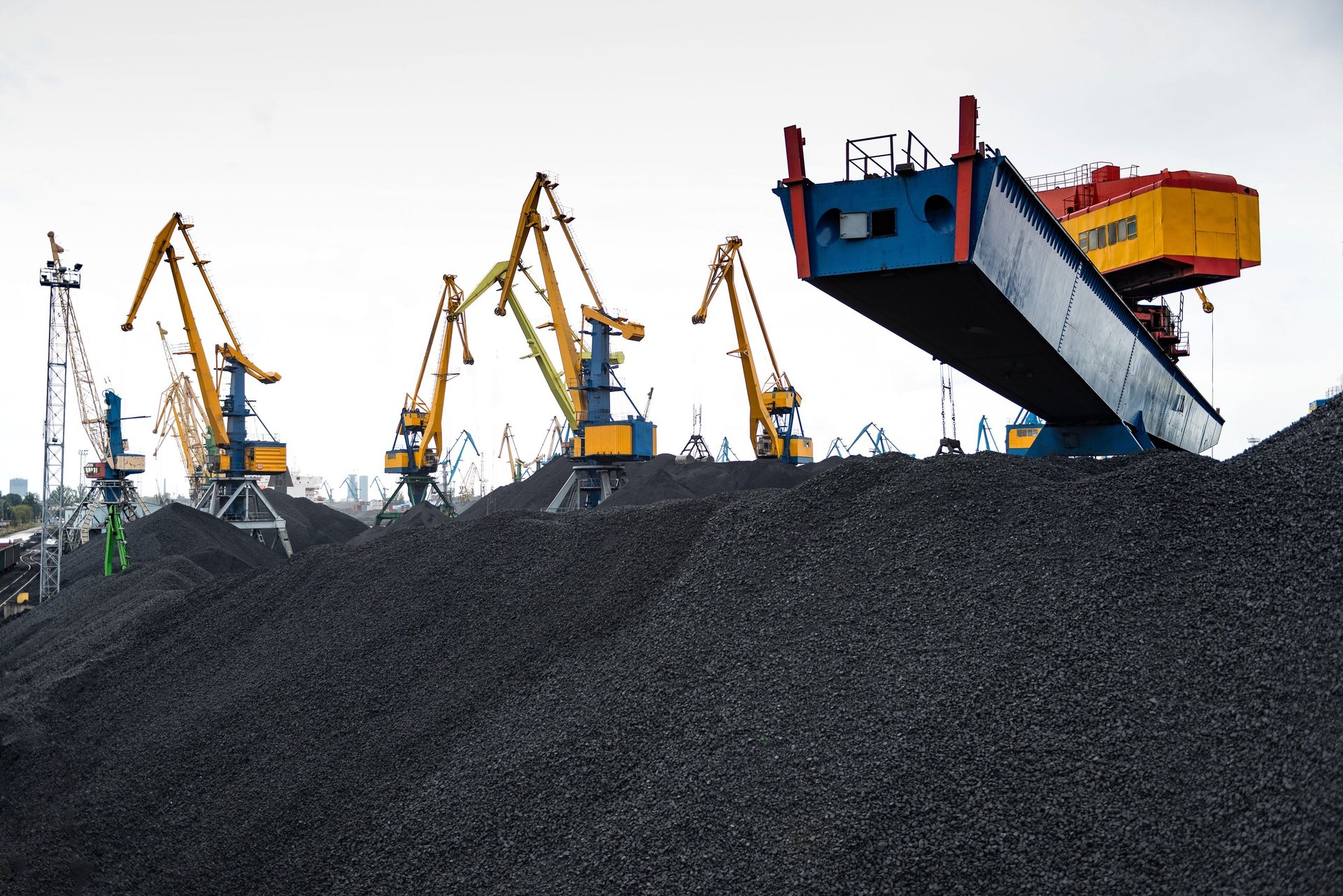 Bulk iron ore being handled at a port, showing the form material arrives in for a destination.