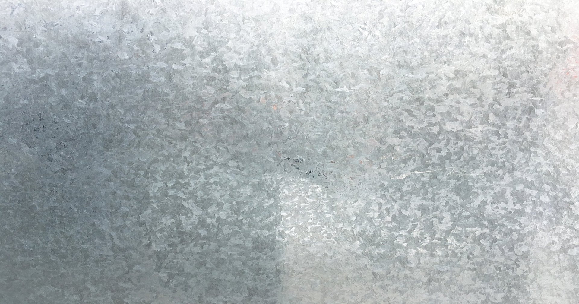 Close-up of galvanized zinc-coated steel sheet surface showing the coating texture